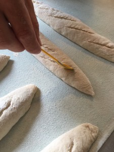 Met een scherp scheermes worden de broden ingesneden. 